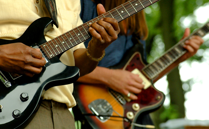 Close up of two people playing guitars